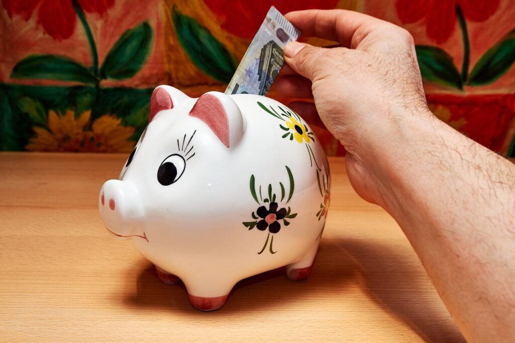 Darren-Yaw-Singapore-Putting-Money-On-White-Piggy-Bank